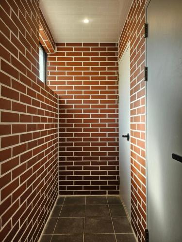 a brick hallway with a door and a brick wall at Mido Hostel in Seogwipo