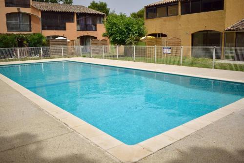 une grande piscine bleue devant un immeuble dans l'établissement Vacances pour tous en Camargue, à Arles