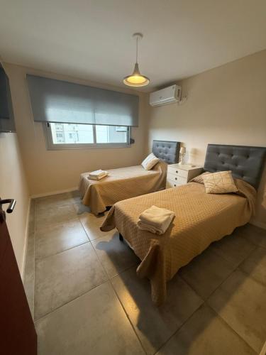 a room with two beds and a window at Departamento 3 Habitaciones Zona Cincuentenario in Formosa
