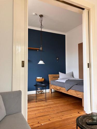 ein Schlafzimmer mit einem Bett und einer blauen Wand in der Unterkunft Lindas Diekblick, 2 Schlafzimmer, EG mit Terrasse in Elsfleth