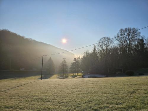 a field of grass with the sun in the sky at Font Neuve in Souillac
