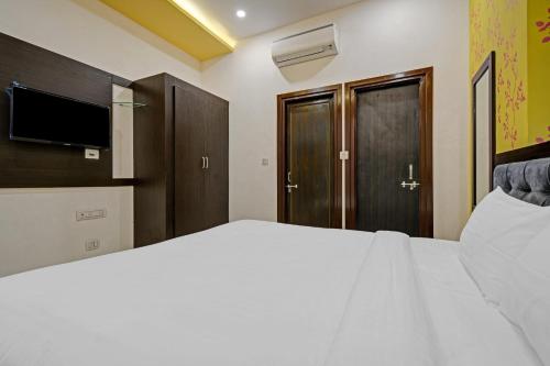 a bedroom with a large bed and a television at Capital O Maharana Palace in Udaipur