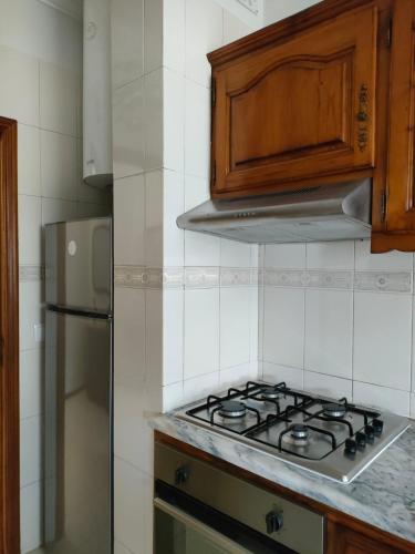 a kitchen with a stove and a refrigerator at Apartamento T2 Amorosa Beach in Viana do Castelo