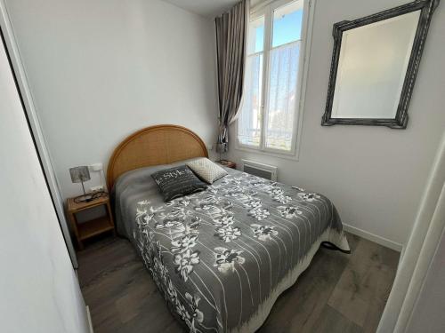 une petite chambre avec un lit et un miroir dans l'établissement Maison cosy proche plage Boisvinet, 2 chambres, cour, parking, Wi-Fi, à Saint-Gilles-Croix-de-Vie - FR-1-324-133, à Saint-Gilles-Croix-de-Vie