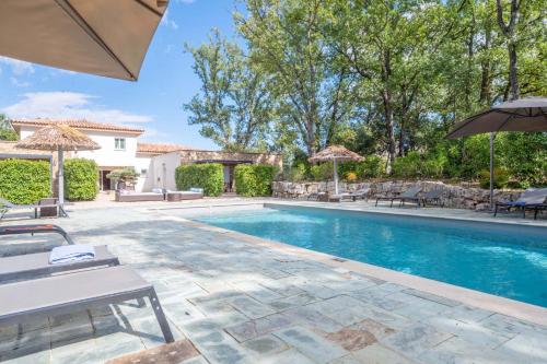 - une piscine avec des chaises et des parasols à côté d'une maison dans l'établissement 83zenvilla-2, à Montauroux
