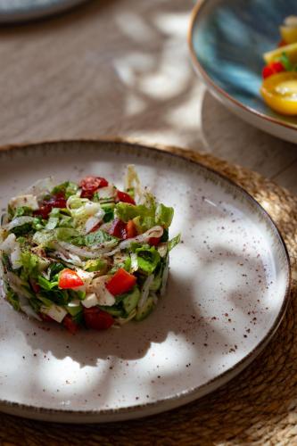 a plate with a salad on a table at XUMA Bungalows in Bodrum City