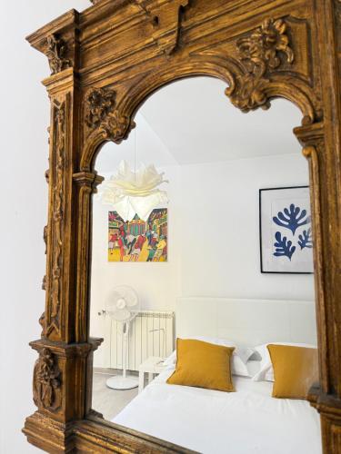 - une chambre avec un grand miroir en bois au-dessus d'un lit dans l'établissement Le Favorin 1, à Arles