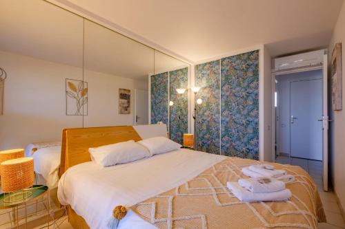 une chambre avec un grand lit avec des serviettes dessus dans l'établissement Appartement La Perle Marine - Welkeys, à Cogolin