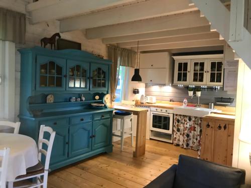 a kitchen with a blue island in a room at Domki nad morzem Sasino Mojo Miodno Checz in Sasino