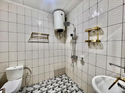 a bathroom with a toilet and a sink at Maison Chic et confortable à la poste centrale in Yaoundé