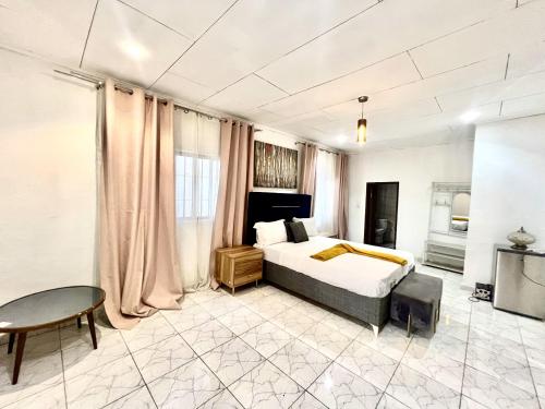 a bedroom with a bed and a table in a room at Maison Chic et confortable à la poste centrale in Yaoundé