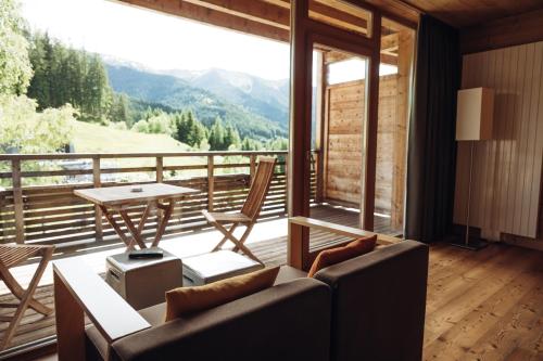 a living room with a couch and a table at Holzhotel Forsthofalm in Leogang