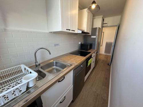 une cuisine avec un évier et un plan de travail dans l'établissement Appart 3 pièces, 2 chambres, 5-6 pers, balcon, garage, Saint-Jean-de-Monts - FR-1-224C-321, à Saint-Jean-de-Monts