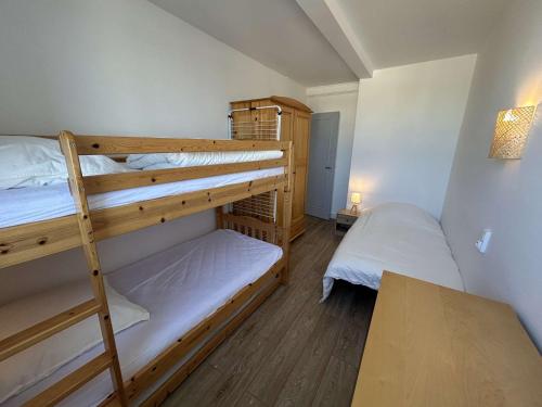 Cette petite chambre comprend 2 lits superposés et une table. dans l'établissement Appart 3 pièces, 2 chambres, 5-6 pers, balcon, garage, Saint-Jean-de-Monts - FR-1-224C-321, à Saint-Jean-de-Monts