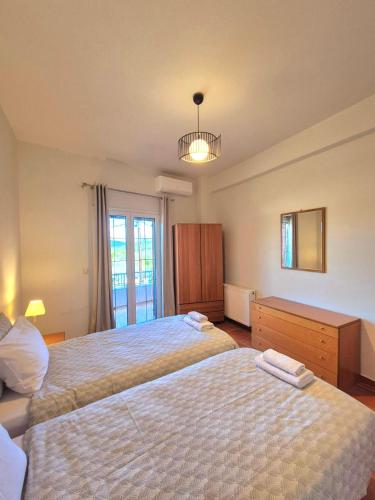 a bedroom with two beds and a window at J&B Countryside Life in Ágios Matthaíos