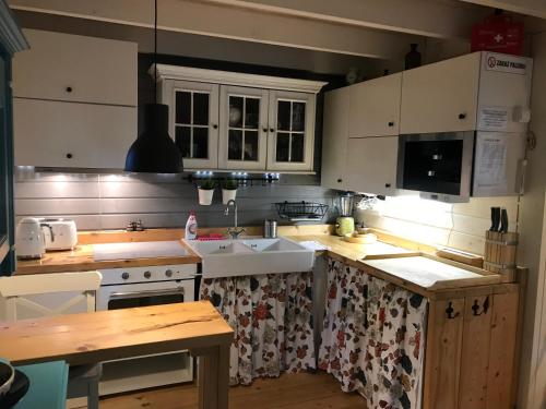 a kitchen with white cabinets and a sink at Domki nad morzem Sasino Mojo Miodno Checz in Sasino