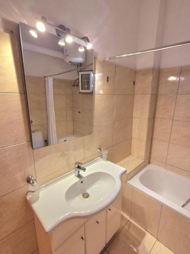 a bathroom with a sink and a tub and a mirror at J&B Countryside Life in Ágios Matthaíos
