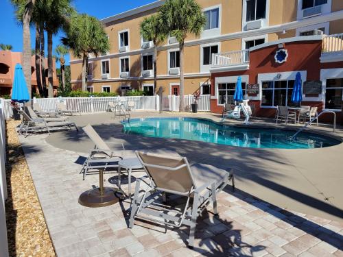 a swimming pool with chairs and a table and a building at Holiday Inn Express Hotel & Suites - The Villages by IHG in The Villages