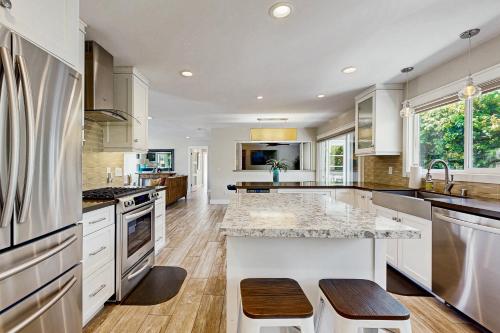 a kitchen with white cabinets and a marble counter top at Ola Vista in San Clemente
