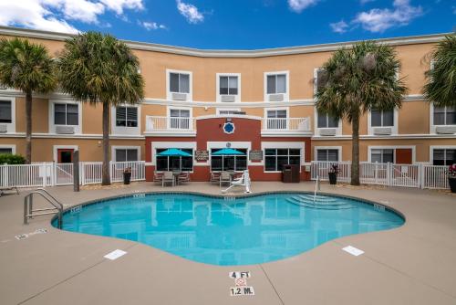 a swimming pool in front of a hotel with a building at Holiday Inn Express Hotel & Suites - The Villages by IHG in The Villages