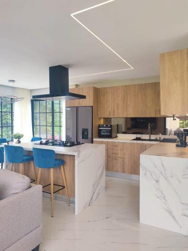 a kitchen with a white counter and wooden cabinets at AmazINN Places Border Villages Valley in Valle de Anton
