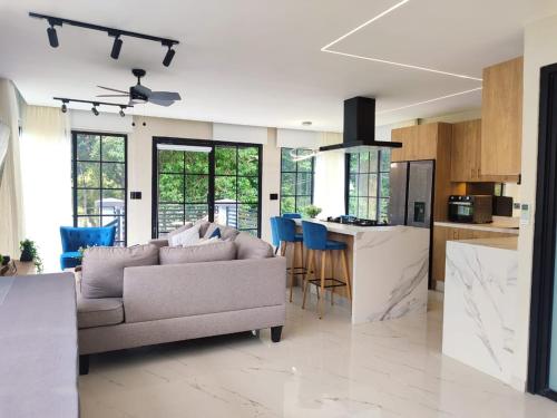 a living room with a couch and a kitchen at AmazINN Places Border Villages Valley in Valle de Anton