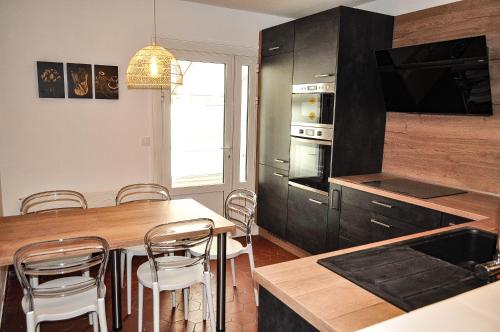 une cuisine avec une table et quelques chaises dans l'établissement La Villa du Brittany, à La Baule
