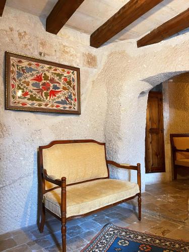 a bench in a room with a painting on the wall at Gedik Cave Hotel in Goreme