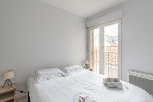 une chambre blanche avec un lit et une fenêtre dans l'établissement Le Clémenceau - Centre-ville - Wifi, à Pornic