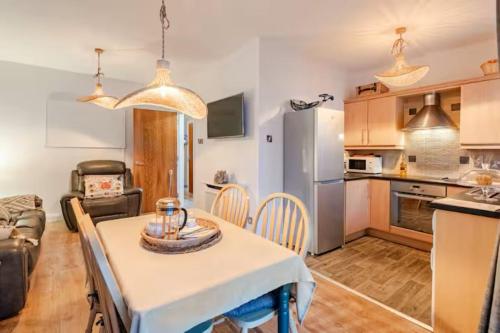 a kitchen and living room with a table and chairs at Harbour Sound Apartment, Ballycastle, Causeway Coast in Ballycastle