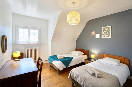 une chambre avec deux lits et une table avec des lampes dans l'établissement La maison de la rade - 200m de la plage, à Larmor-Plage