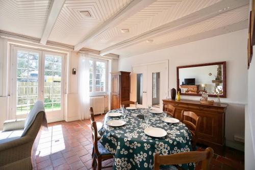 une salle à manger avec une table et des chaises et une fenêtre dans l'établissement La maison de la rade - 200m de la plage, à Larmor-Plage
