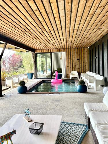 - une piscine dans une maison dotée d'un plafond en bois dans l'établissement La Corniche, Villa d'architecte avec piscine, 2mn mer à Houlgate, à Houlgate