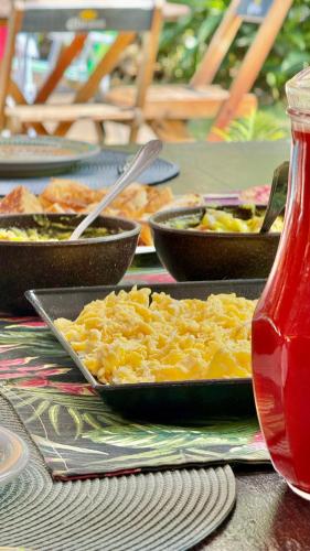 a table with plates of food and bowls of food at Mangará Hostel e Hospedaria in Ilhabela