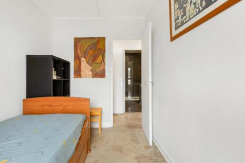 une petite chambre avec un lit et une cuisine dans l'établissement Cosy et Mer - Piscine partagée, au Cap d'Agde