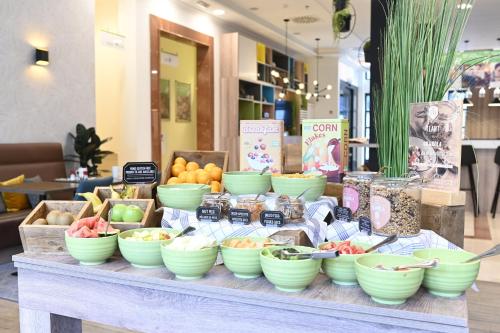 a buffet with bowls of fruits and vegetables on a table at Holiday Inn Brussels Schuman by IHG in Brussels