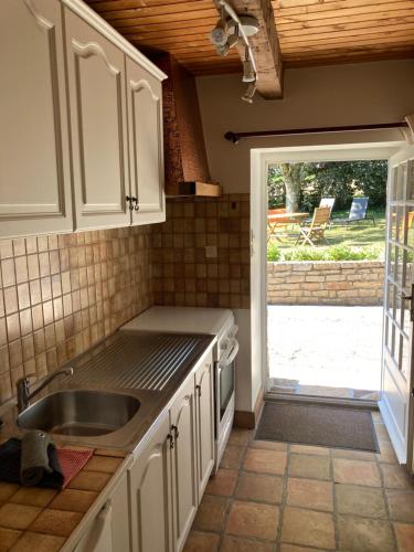 une cuisine avec un évier et une porte donnant sur une cour. dans l'établissement Benniel bihan maison de vacances à 5 minutes des plages de la baie de Douarnenez, à Plomodiern