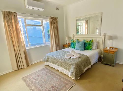 a bedroom with a bed with a mirror and a window at Sagelands for business travel & family getaways in Durban
