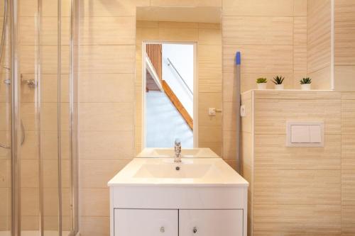 une salle de bain avec un lavabo blanc et une douche dans l'établissement Saint PonsCocon au pied du Panier avec balcon, à Marseille