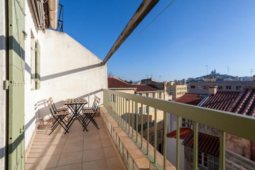 un balcon avec des chaises et une table sur un immeuble dans l'établissement Saint PonsCocon au pied du Panier avec balcon, à Marseille