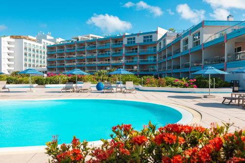 a swimming pool in front of a hotel at Royal Islander Club Resort La Terrasse in Lowlands