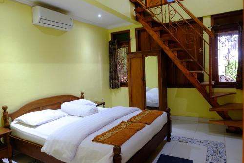 a bedroom with a bed and a spiral staircase at Villa Alicia - Pavillion Lily in Yogyakarta