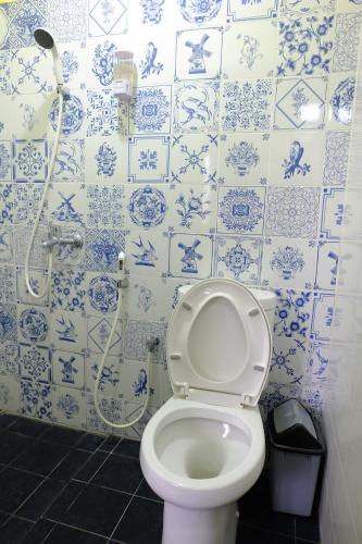 a bathroom with a toilet with blue and white tiles at Villa Alicia - Pavillion Lily in Yogyakarta