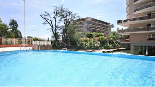 une grande piscine devant un immeuble dans l'établissement 3 bedroom penthouse apartment near cannes, à Mandelieu-la-Napoule