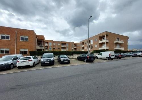a row of cars parked in a parking lot next to a building at Silver Waves in Vila Nova de Gaia