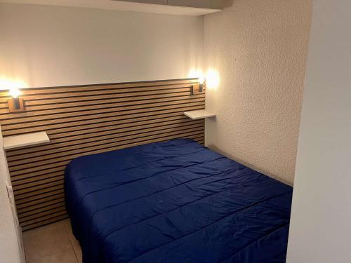 - une chambre avec un lit bleu et deux lumières sur le mur dans l'établissement Appartement avec Terrasse, Clim, Parking Privé - Cavalaire-sur-Mer - FR-1-226B-153, à Cavalaire-sur-Mer