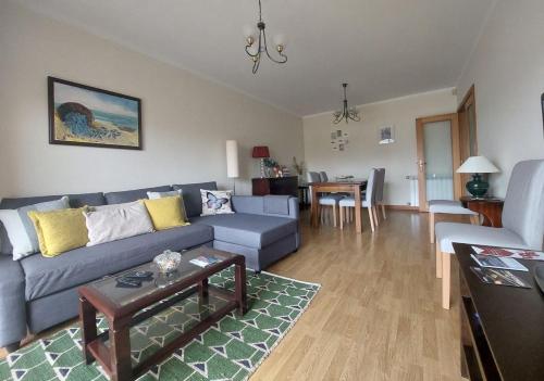a living room with a blue couch and a table at Silver Waves in Vila Nova de Gaia