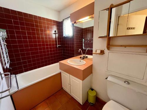 La salle de bains est pourvue d'un lavabo, de toilettes et de carrelage rouge. dans l'établissement Studio cosy à 50m de la plage avec parking privé - Cavalaire-sur-Mer - FR-1-226B-37, à Cavalaire-sur-Mer