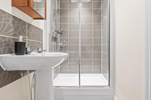a bathroom with a sink and a shower at Stylish 4 Bedroom House in St Neots w Free Parking in Saint Neots