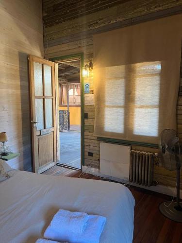 a bedroom with a bed and a door to a porch at mercado NL in Villa La Angostura